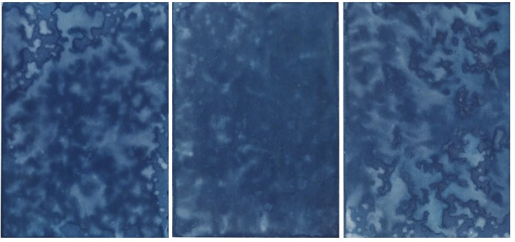 Three sheets of paper coated with the chemicals of a cyanotype and left in the rain exhibit the droplets and accumulating water of a January storm by Photographer and artist Megan Kennedy